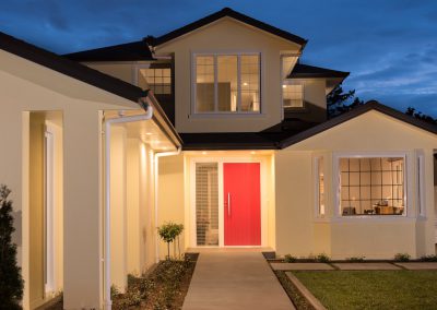 modern home with lattice windows and red entrance door